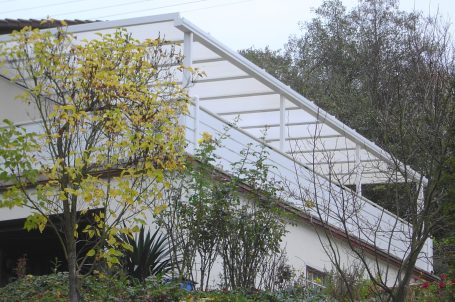 Moderne Architektur mit schrägem Dach und angrenzendem Garten.